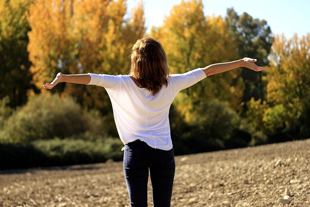 Woman outside in autumn with her arms out